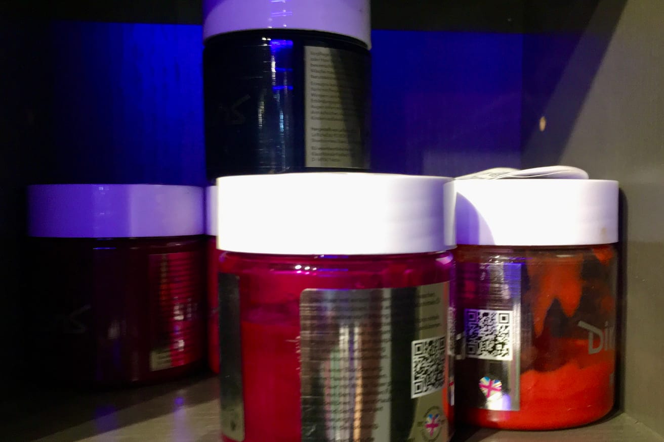 Rows of semi-permanent hair color tubes arranged by shade on a salon shelf.