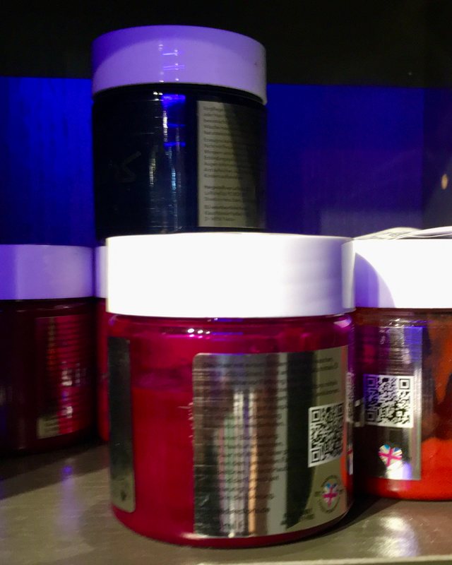 Tubs of semi-permanent colour lined up on the colour-room shelf