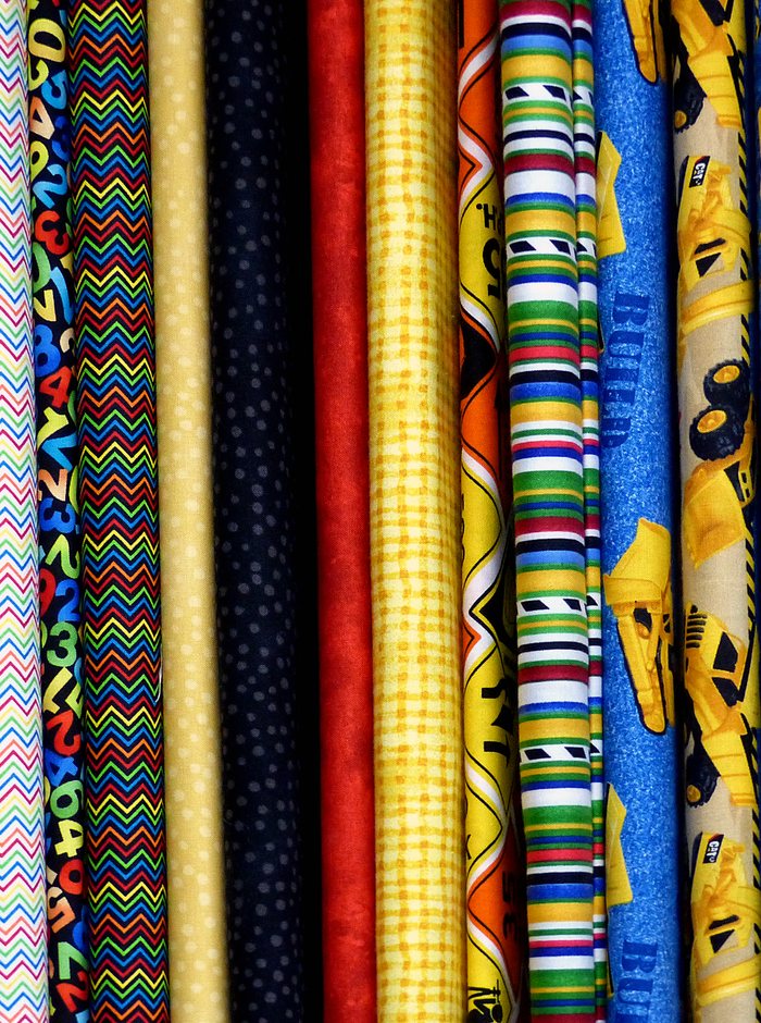 Bolts of cloth stacked on end in a fabric store