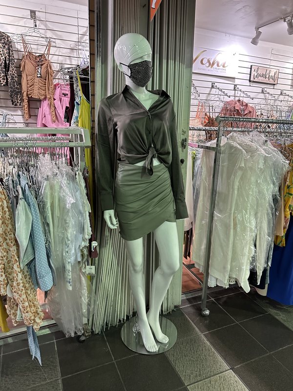 A dress form wearing a sequinned mask and evening dress
