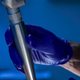 Gloved hand holding a laser handpiece