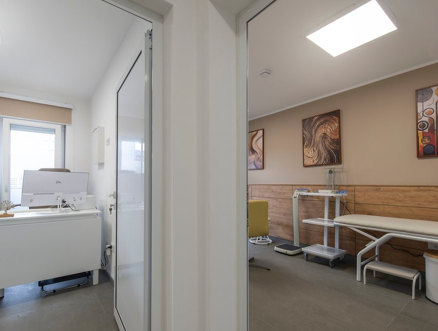 Consulting desk seen through a doorway, with a treatment room beyond