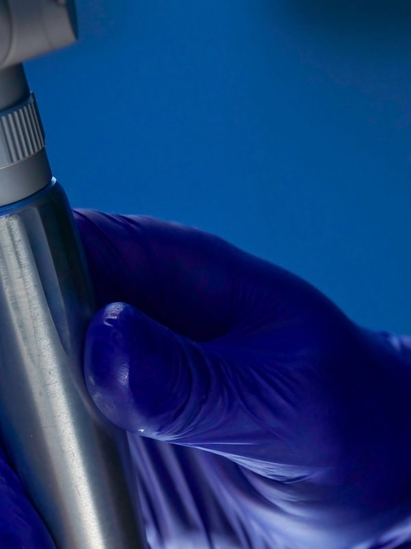 Gloved hand holding the laser handpiece before a treatment