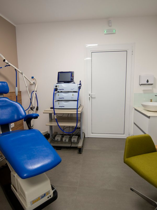 Treatment room with a reclining chair and an equipment trolley