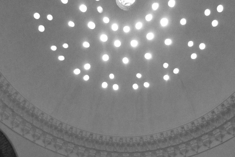 A domed plaster ceiling pierced with small star-shaped lights.