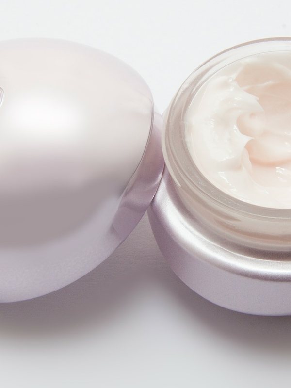 Two open jars of pale cosmetic cream