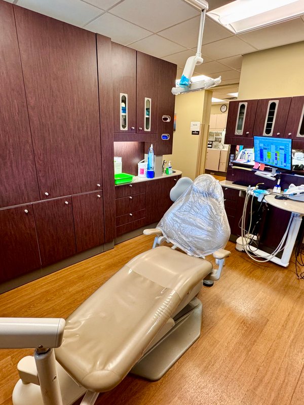 A dental chair and delivery unit in a treatment room