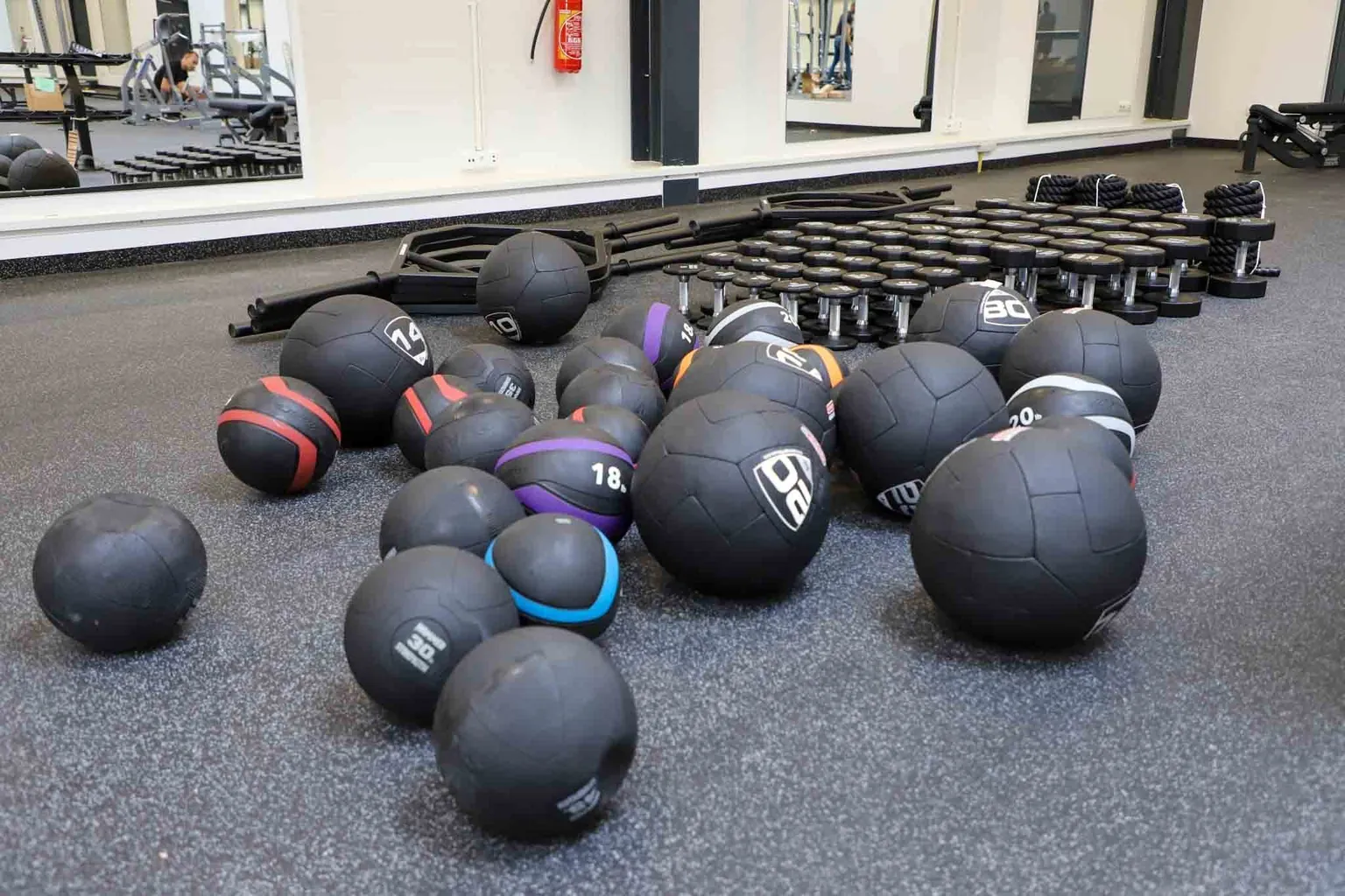 Wide empty workshop lab with medicine balls and racked weights