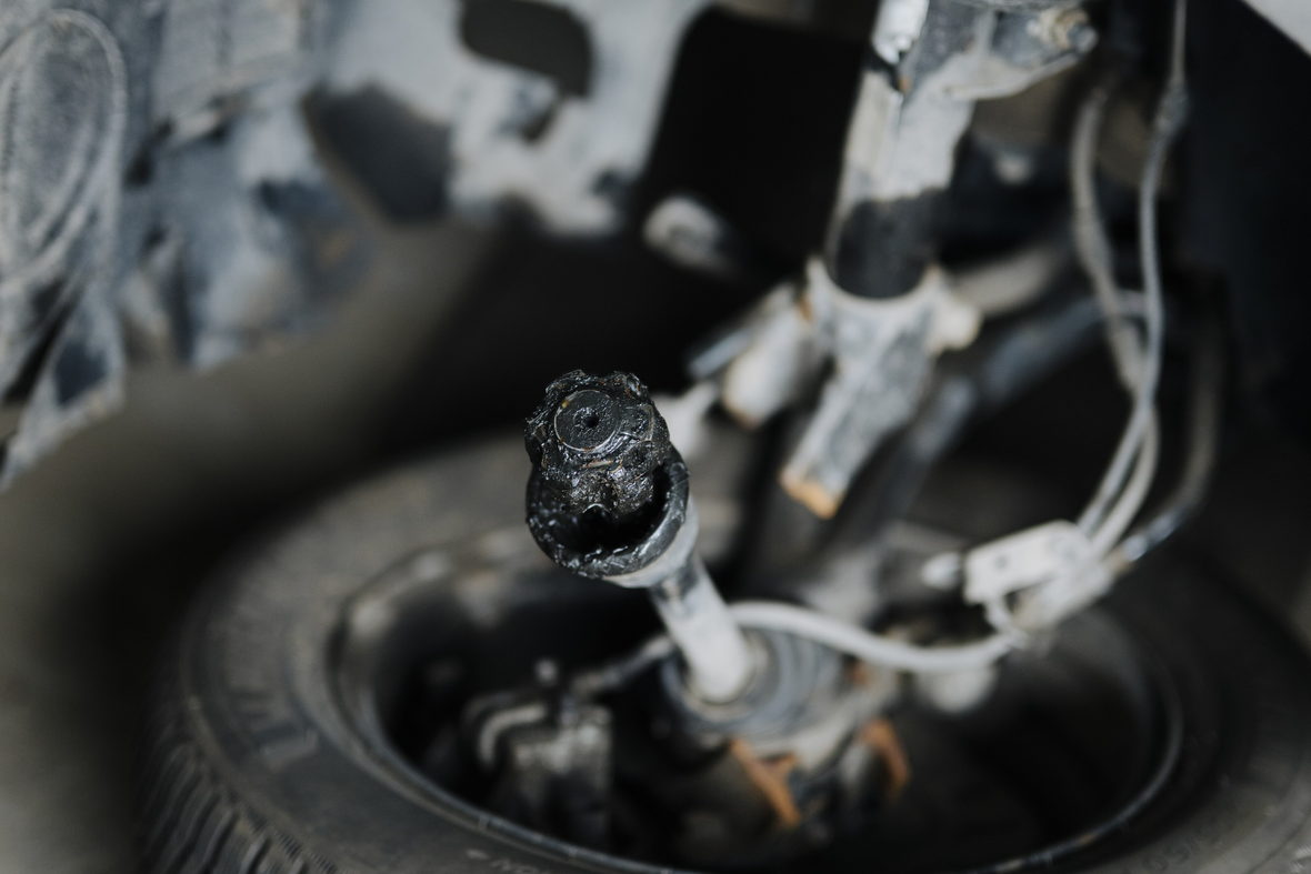 A wheel and suspension assembly showing wear on a lifted vehicle.