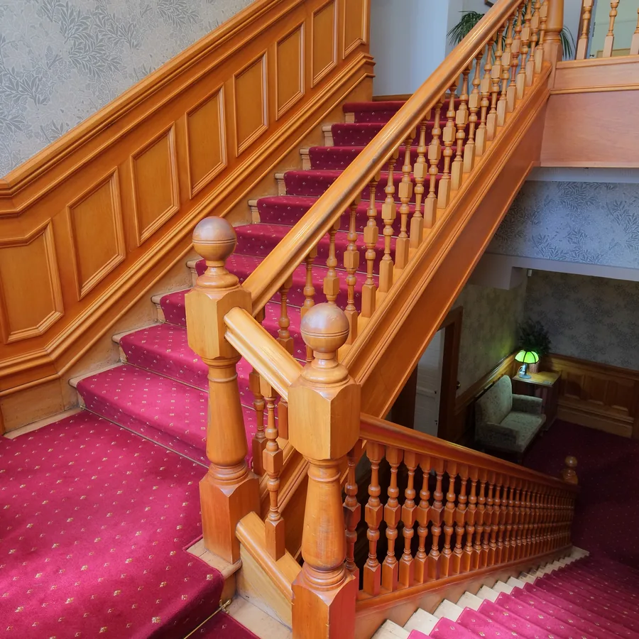Wooden staircase with a red patterned stair runner