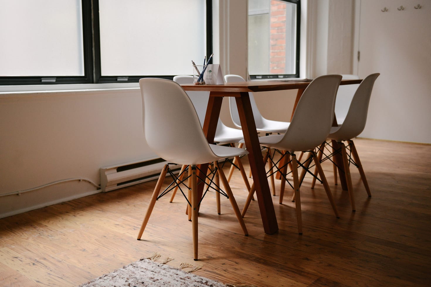 An empty meeting room with a table and chairs in natural daylight.