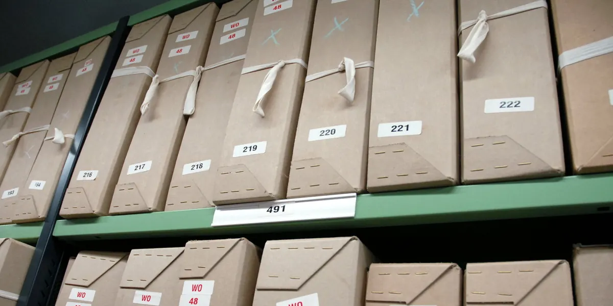 Numbered archive boxes arranged in sequence on repository shelving.
