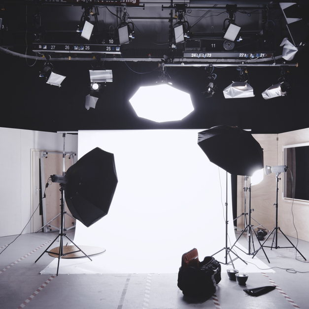 A shooting bay with a white paper sweep, two octabox lights on stands and an overhead lighting rig.