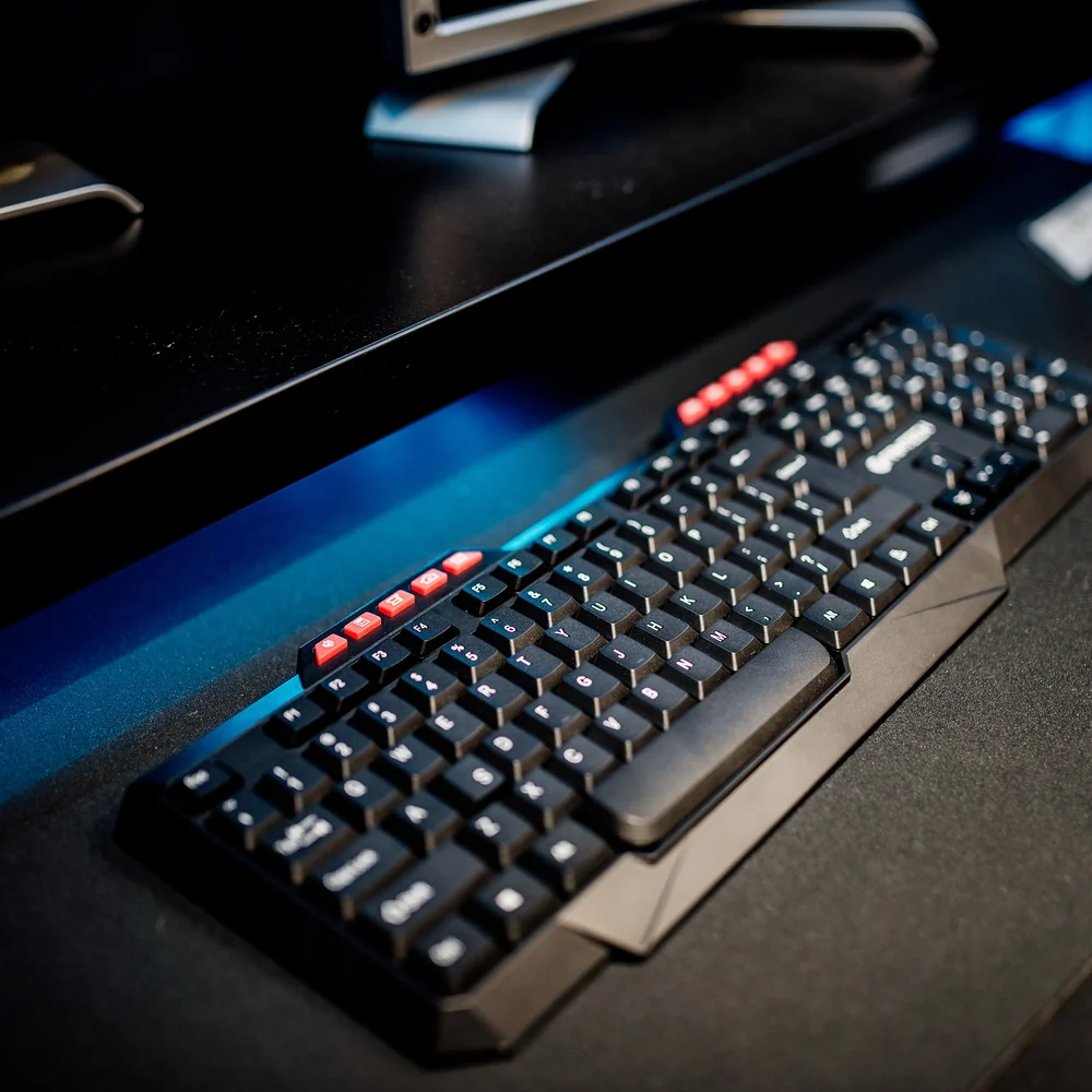 Mechanical keyboard on a dark desk under a monitor