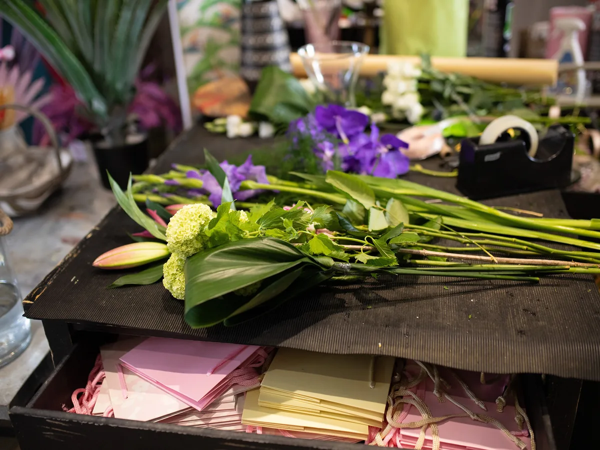 Cut stems, wrapping paper and gift cards on the florist worktable